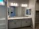 Double vanity bathroom with granite countertop and large mirror at 3290 W San Cristobal Rd, San Tan Valley, AZ 85144