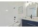 Updated bathroom with a navy vanity, white subway tile, and modern fixtures at 3350 W Wethersfield Rd, Phoenix, AZ 85029