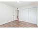 Bedroom with white walls, wood floors and a sliding door closet at 3350 W Wethersfield Rd, Phoenix, AZ 85029