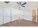Bedroom with ceiling fan, sliding door closet, and en-suite bathroom at 3350 W Wethersfield Rd, Phoenix, AZ 85029