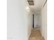 Bright hallway with light wood laminate flooring and access to bedrooms at 3350 W Wethersfield Rd, Phoenix, AZ 85029
