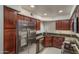 Kitchen with dark wood cabinets, granite countertops, and stainless steel appliances at 8787 E Mountain View Rd # 2008, Scottsdale, AZ 85258