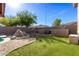 Landscaped backyard with a pool, patio, and rock waterfall at 17329 W Banff Ln, Surprise, AZ 85388