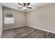 Bright bedroom with ceiling fan and wood-look floors at 17750 W Larkspur Dr, Surprise, AZ 85388