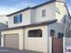 Two story house with tan exterior, two car garage, and dark brown gate at 2550 N 149Th Ave, Goodyear, AZ 85395