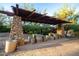 Stone picnic tables under a shaded pergola in a desert setting at 29411 N 123Rd Ln, Peoria, AZ 85383