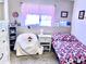 bedroom with pink and floral decor, a twin bed, and a comfy armchair at 404 E Paseo De Isabella --, Casa Grande, AZ 85122