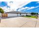 White single story home with a two car garage and grassy front yard at 7309 W Claremont St, Glendale, AZ 85303