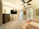 Bright bedroom with a king-size bed, large TV, and ensuite bathroom access at 10063 E Cinnabar Ave, Scottsdale, AZ 85258