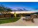 Landscaped backyard with lawn, lounge chairs, and mountain views at 10737 E Scopa Trl, Scottsdale, AZ 85262