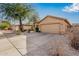 Tan house with a two-car garage and nicely landscaped front yard at 12549 W Woodland Ave, Avondale, AZ 85323