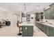 Modern kitchen with green cabinets and a large island at 12874 W Flynn Ct, Glendale, AZ 85307