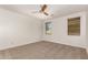 Bright bedroom featuring ceiling fan and neutral carpeting at 18080 W Desert Ln, Surprise, AZ 85388