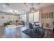 Open concept dining area with a view of the living room, hardwood floors and modern light fixture at 29381 N 123Rd Ave, Peoria, AZ 85383