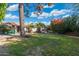 Spacious backyard with grassy lawn, mature trees, and a seating area at 8340 E Thomas Rd, Scottsdale, AZ 85251