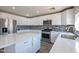 Modern kitchen with white cabinets, quartz countertops, and stainless steel appliances at 13309 N 124Th Ave, El Mirage, AZ 85335