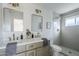 Modern bathroom with double vanity, large mirror, and walk-in shower at 1436 E Downing St, Mesa, AZ 85203