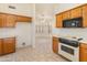 Kitchen with wood cabinets, tiled floor, and view into adjacent dining area at 14543 W Bison Path, Surprise, AZ 85374