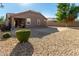 Large backyard with gravel, shrubs, and a covered patio at 16468 W Mariposa Grande --, Surprise, AZ 85387