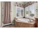 Relaxing bathroom with a large soaking tub and plantation shutters at 21774 E Camacho Rd, Queen Creek, AZ 85142