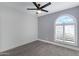 Well-lit bedroom with tile floors, ceiling fan, and arched window with shutters at 6608 W Mercer Ln, Glendale, AZ 85304