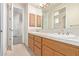 Double vanity with wood cabinets and a large mirror at 8360 S Homestead Ln, Tempe, AZ 85284