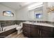 Updated bathroom with a soaking tub, gray tile, and modern vanity at 19418 N 86Th Dr, Peoria, AZ 85382