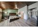 Main bedroom with wood-look floors, ceiling fan, and access to the bathroom at 19418 N 86Th Dr, Peoria, AZ 85382