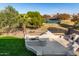 Outdoor kitchen, fireplace, and grassy backyard with community views at 43576 W Snow Dr, Maricopa, AZ 85138