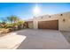 Single-story home with stucco exterior, wood garage door, and desert landscaping at 5411 E Seven Palms Dr, Cave Creek, AZ 85331