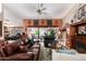 Living room with leather sofas, ceiling fan, and sliding glass doors at 9110 W Oraibi Dr, Peoria, AZ 85382