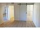 Bright bedroom with wood-look floors and barn door entry to bathroom at 1217 N Miller Rd # 8, Scottsdale, AZ 85257
