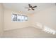 Bright bedroom with carpeted floor, ceiling fan, and large window with blinds at 12434 W Eveningside Dr, Sun City West, AZ 85375