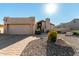 Tan stucco house with a tile roof, attached garage, and landscaped front yard at 25401 S Cloverland Dr, Sun Lakes, AZ 85248