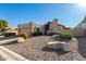 Tan stucco house with a tile roof, attached garage, and landscaped front yard at 25401 S Cloverland Dr, Sun Lakes, AZ 85248