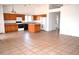 Open kitchen with oak cabinets, island, and tile floor at 7571 W Pasadena Ave, Glendale, AZ 85303