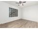 Spacious bedroom with wood-look floors and a large window at 8722 W Lewis Ave, Phoenix, AZ 85037