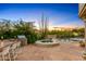 Outdoor kitchen, spa, and pool surrounded by a beautifully landscaped yard at 10420 E Morning Vista Ln, Scottsdale, AZ 85262