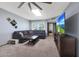 Living room with sectional sofa, TV, and ceiling fan at 18822 N 134Th Ave, Sun City West, AZ 85375