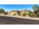 Tan house with three-car garage and desert landscaping at 19714 N Rim Dr, Surprise, AZ 85374