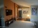 Living room with a large flat-screen TV and orange accent wall at 21008 N 141St Ave, Sun City West, AZ 85375