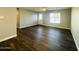 Open living room with dark vinyl flooring and a view of the kitchen at 4222 N 48Th Ave, Phoenix, AZ 85031