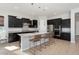 Modern kitchen with island, dark cabinetry, and stainless steel appliances at 4779 N 205Th Gln, Buckeye, AZ 85396
