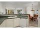 Kitchen boasts white cabinets, tile countertops, and views of the dining area at 7887 N 16Th St # 116, Phoenix, AZ 85020