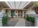 Covered entryway with a stone path and lush landscaping at 10274 N 109Th Ave, Sun City, AZ 85351