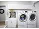 Bright laundry room with modern washer, dryer, and cabinets at 14401 W Gunsight Dr, Sun City West, AZ 85375