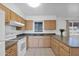 Functional kitchen with wood cabinetry, white appliances, and tile flooring at 2931 E Danbury Rd, Phoenix, AZ 85032