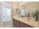 Dual vanity bathroom with light countertops, wooden cabinets, and a large mirror at 3931 N Golf Dr, Buckeye, AZ 85396