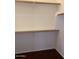 Walk-in closet with wood shelving and hanging rods at 42424 N Gavilan Peak Pkwy # 40206, Anthem, AZ 85086