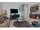 Living room featuring a fireplace, leather furniture, and large TV at 7075 W Noble Prairie Way, Florence, AZ 85132